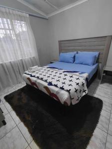 een slaapkamer met een groot bed met blauwe kussens bij Mama R's Hostel Life Experience in Newcastle