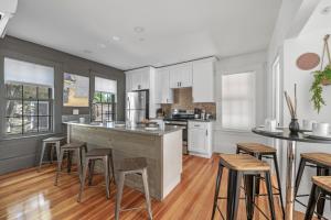 a kitchen with white cabinets and a island with bar stools at Broadway in Rockport