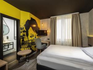 a hotel room with a bed and a desk at ibis Styles Dresden Neustadt in Dresden