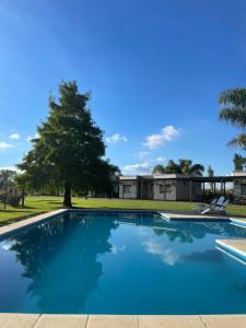 a swimming pool in front of a house at Complejo Bohio Hotel Boutique in Lobos