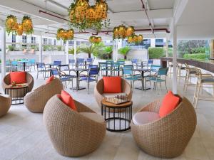 een terras met stoelen, tafels en tafelbladen bij Mövenpick Hotel Apartments Downtown Dubai in Dubai