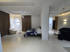a bedroom with a bed and a living room with a couch at U&U place in Uyo +22 photos