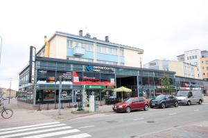 a building with cars parked in front of a street at Santalux Apartment in Rovaniemi