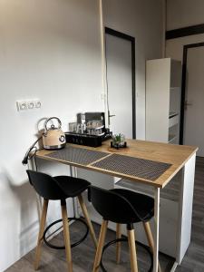 eine Küche mit einem Tisch, zwei Stühlen und einem Wasserkocher in der Unterkunft Bel Horizon in La Désirade