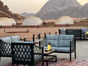 un gruppo di sedie e un divano nel deserto di Shell Luxury Camp a Wadi Rum
