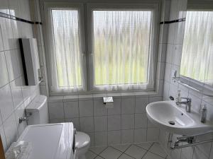 a white bathroom with a toilet and a sink at SielundMeer in Neuharlingersiel +22 photos