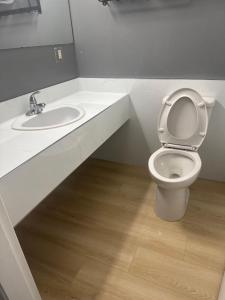een witte badkamer met een toilet en een wastafel bij Canadas Best Value Inn Kelowna in Kelowna +5 foto's