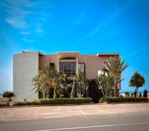 ein Haus mit Palmen vor einer Straße in der Unterkunft YMY Beach House in Agadir