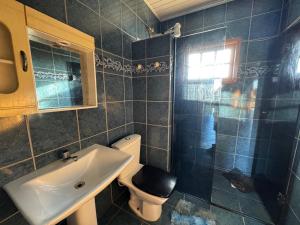 a bathroom with a sink and a toilet and a shower at Casa com piscina in Tramandaí +7 photos