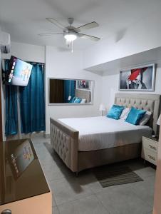 a bedroom with a bed and a flat screen tv at Boca del Mar III, apartamento 706A in Boca Chica +48 photos