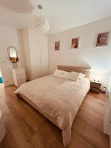 ein Schlafzimmer mit einem großen Bett und einem Kronleuchter in der Unterkunft Maison spacieuse avec grand jardin Cosne-sur-Loire in Saint-Père