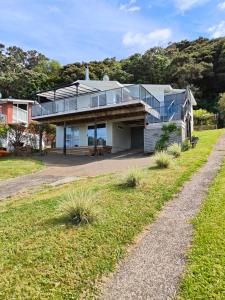 une maison avec une façade en verre sur une colline dans l'établissement Hillside Haven, à Whitianga 7 autres photos