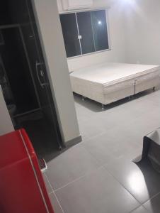 een slaapkamer met een bed en een raam bij Litoral suítes in Araruama