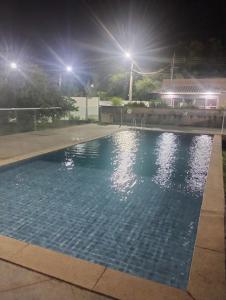 a swimming pool at night with lights at Litoral suítes in Araruama