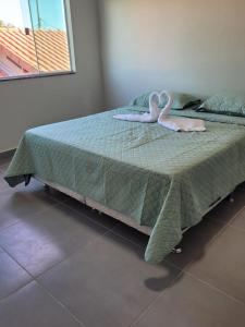 Twee roze zwanen zitten op een bed. bij Litoral suítes in Araruama