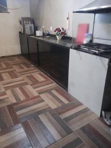 a kitchen with a counter top and a wooden floor at Litoral suítes in Araruama