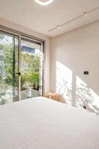 Un dormitorio con una cama blanca y una ventana grande. en Harmony Garden, en Casablanca