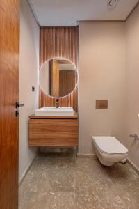 Un baño con lavabo, inodoro y espejo. en Harmony Garden, en Casablanca
