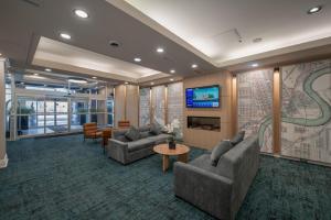 a lobby with couches and a tv in a building at Campus Tower Suite Hotel in Edmonton