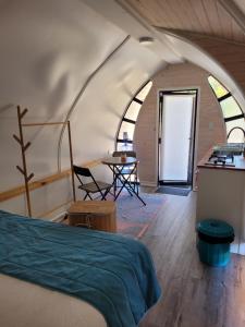 a room with a bed and a table and chairs at Achibueno Glamping in Linares