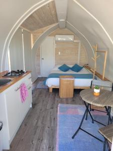 a bedroom with a bed and a kitchen and a table at Achibueno Glamping in Linares