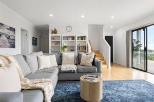 a living room with a couch and a table at Hazel Beach House - Ocean Views & Coastal Charm in Goolwa South