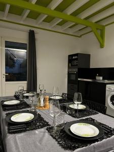einen Esstisch mit Tellern und Weingläsern darauf in der Unterkunft Bel Horizon in La Désirade + 3 Fotos
