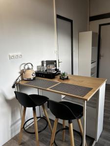 eine Küche mit einem Tisch, zwei Stühlen und einem Wasserkocher in der Unterkunft Bel Horizon in La Désirade