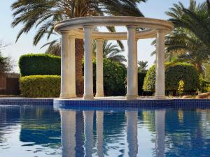 a gazebo next to a swimming pool at Mövenpick Resort & Residences Aqaba in Aqaba