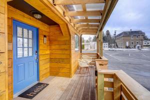 a wooden porch with a blue door on a house at 'Little House on the Lot' Dryden Townhome: Pets OK in Dryden
