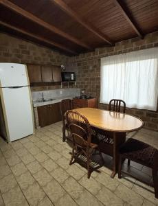 una cucina con un tavolo e un frigorifero bianco di Casa 2 dormitorios B a Villa Guntz