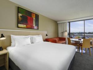 a hotel room with a large bed and a table at Mercure Rockhampton in Rockhampton +68 photos