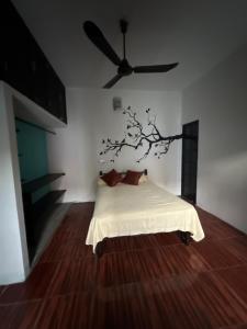 een slaapkamer met een bed met een boom aan de muur bij Casa LA ROCA in Zipolite