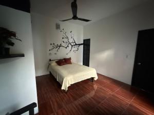 een slaapkamer met een bed en een boom aan de muur bij Casa LA ROCA in Zipolite