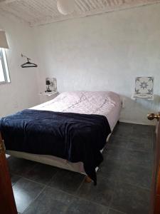 a bedroom with a bed in a white room at La casa de Juan in Cuchilla Alta +27 photos