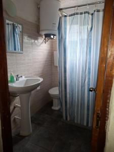 a bathroom with a sink and a shower curtain at La casa de Juan in Cuchilla Alta