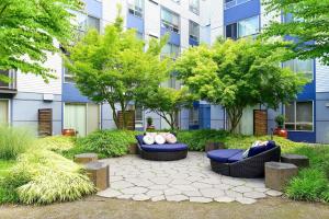 a courtyard with couches and trees in front of a building at Blueground Brighton balcony nr Othello Park SEA-875 in Seattle