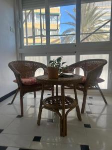 un tavolo con due sedie e un tavolo con una pianta di Benidorm Apartament a Benidorm