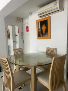 una sala da pranzo con tavolo e sedie in vetro di Benidorm Apartament a Benidorm
