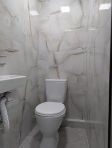 een witte badkamer met een toilet en een wastafel bij Home Sweet in Balaovit