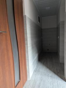 een lege kamer met een houten deur en houten vloeren bij Home Sweet in Balaovit +2 foto's