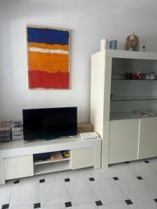 un soggiorno con una TV e un mobile bianco di Benidorm Apartament a Benidorm