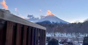 a mountain with a fire in the background with a building at Ondolphin in Narusawa