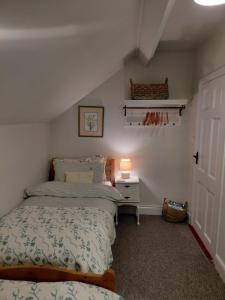 een slaapkamer met twee bedden en een lamp op een tafel bij The Shepherd's Cottage in Ardmore