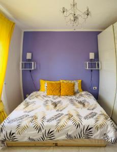a bedroom with a bed with a purple wall at myplace in Tiagua