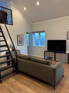 uma sala de estar com um sofá e uma televisão em Brim Guesthouse, with ocean view em Sauðárkrókur