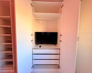a walk in closet with a flat screen tv at myplace in Tiagua