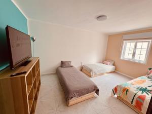 a bedroom with two beds and a flat screen tv at myplace in Tiagua