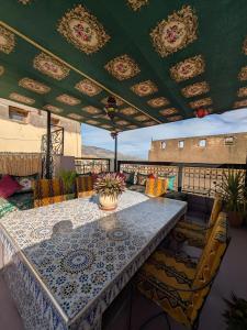 een terras met een tafel en stoelen op een balkon bij Riad Amira Luxury Palace in Fès