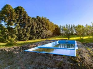 a swimming pool in the middle of a field with trees at Los Almendros in Verónica